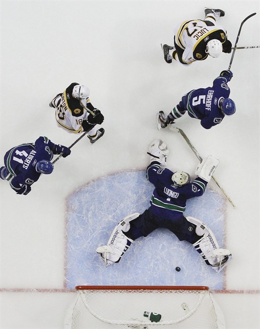 Boston Bruins left wing Milan Lucic (17) shoots the puck past Vancouver Canucks goalie Roberto Luongo (1) as Canucks Christian Ehrhoff (5) and defenseman Andrew Alberts (41) and Boston Bruins right wing Nathan Horton (18) look on in the second period during Game 2 of the NHL hockey Stanley Cup Finals, Saturday, June 4, 2011, in Vancouver, British Columbia. (AP Photo/Julie Jacobson).