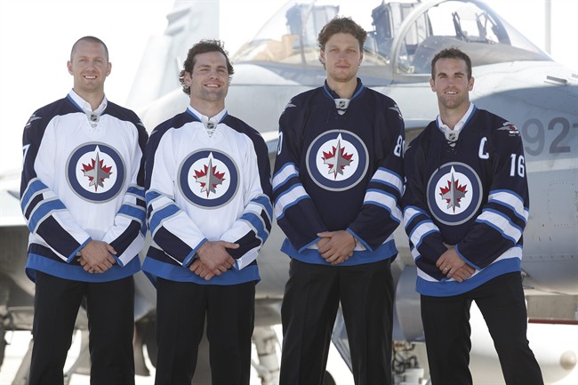 Winnipeg Jets Eric Fehr, left to right, Mark Stuart, Nik Antropov and Andrew Ladd poses for a photo in the new Jets jersey at a Canada Forces base in Winnipeg Tuesday, September 6, 2011. THE CANADIAN PRESS/John Woods.