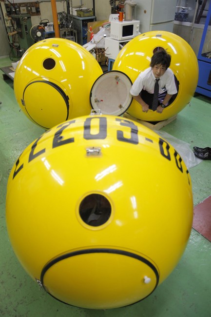 A Cosmo Power Co. employee crawls out from a spherical earthquake and tsunami shelter "Noah" made of fiber enforced plastic at the company's factory in Hiratsuka, west of Tokyo, Friday, Sept. 30, 2011. The Japanese generator maker has developed a modern version of Noah's Ark in case Japan is hit by another massive earthquake and tsunami. The company of just 10 employees completed the first Noah, that has 1.2 meters (4 feet) in diameter and can hold up to four adults inside, earlier this month and already has 500 orders. (AP Photo/Itsuo Inouye).