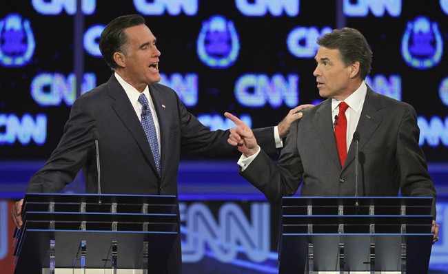 FILE - In this Oct. 18, 2011 file photo, Republican presidential candidates, former Massachusetts Gov. Mitt Romney, left, and Texas Gov. Rick Perry, speak during a Republican presidential debate in Las Vegas. The image of Romney laying a hand on Perry's shoulder may well be remembered long after people have forgotten that the two were squabbling about. Body language speaks volumes in political debates. (AP Photo/Chris Carlson, File).
