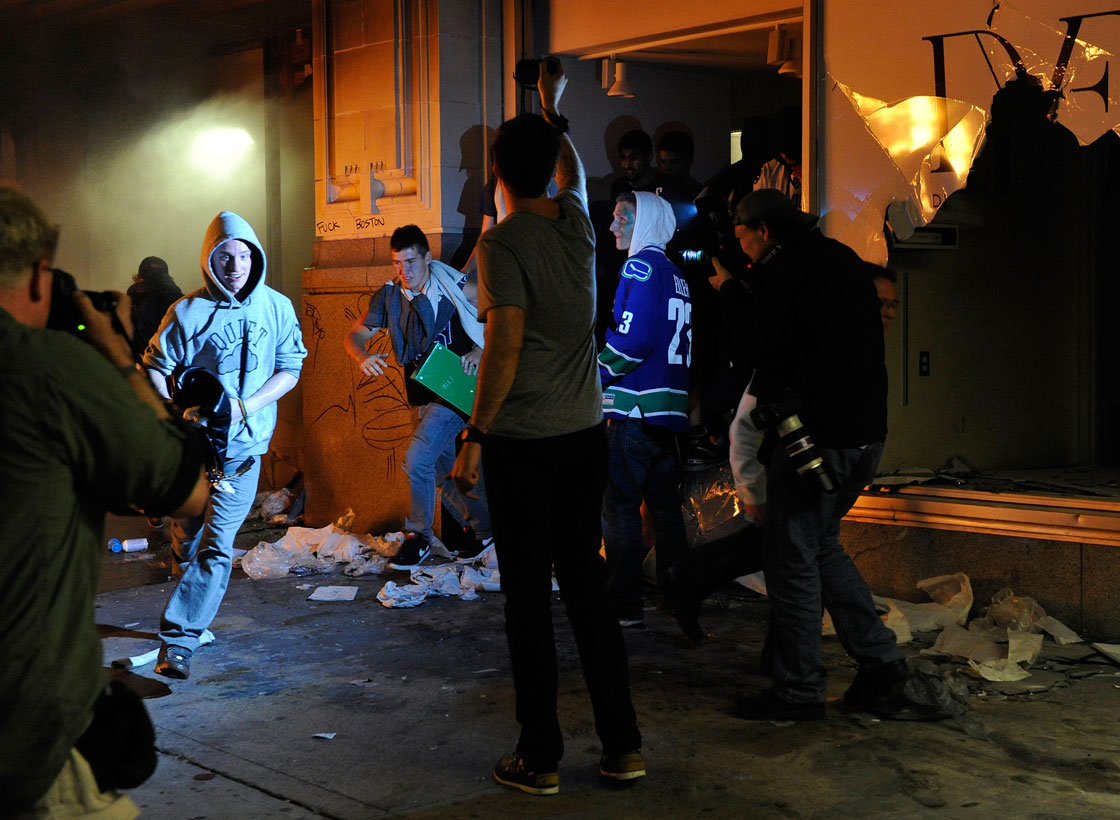 People run out of a Hudson Bay Co store with merchandise on June 15, 2011 in Vancouver, Canada. Vancouver broke out in riots after their hockey team the Vancouver Canucks lost in Game Seven of the Stanley Cup Finals.  