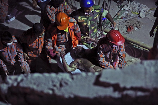 Bangladeshi soldiers and firefighters carry a burned and injured colleague after a fire in a tunnel that rescue workers were using to search for survivors in a building that collapsed Wednesday in Savar, near Dhaka, Bangladesh, Sunday, April 28, 2013.