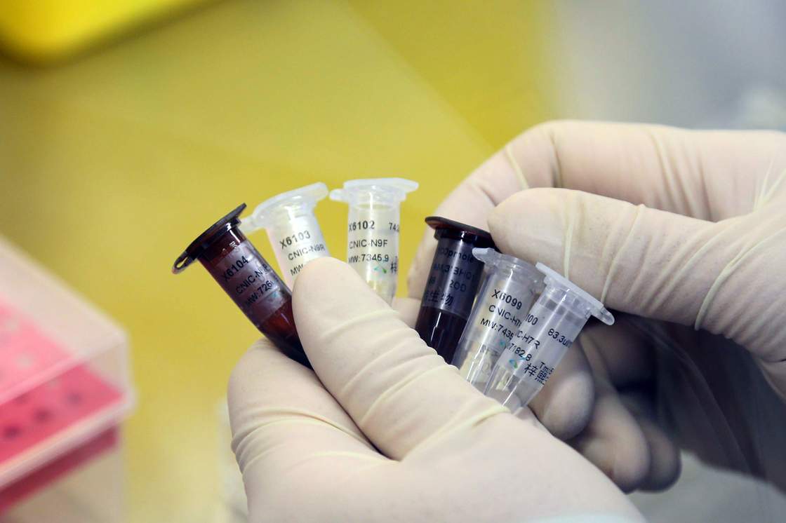 This picture taken on April 3, 2013 shows a Chinese health worker looking at viles as workers prepare an H7N9 virus detection kit at the Center for Disease Control (CDC) in Beijing.