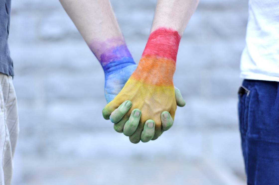 Two gay men holding their hands painted with the colors of the LGBT movement, photographed at Montreal on May 24, 2012.