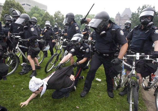 Police club an activist during the G20 Summit in Toronto, June 26, 2010. 