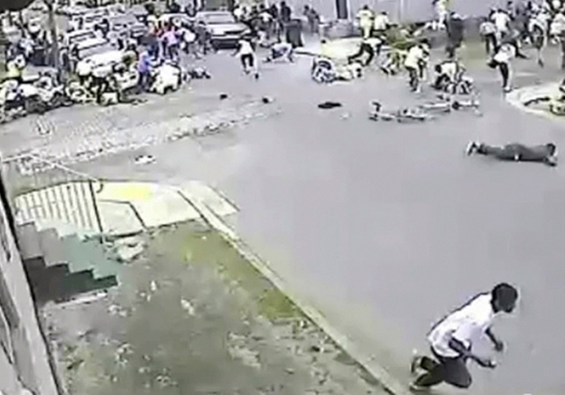 In this image taken from video and provided Monday, May 13, 2013, by the New Orleans Police Department, a possible shooting suspect in a white shirt, bottom center, shoots into a crowd of people, Sunday in New Orleans. Police believe more than one gun was fired in the Mother’s Day gunfire that wounded 19 people during a New Orleans neighborhood parade. (AP Photo/New Orleans Police Department)
