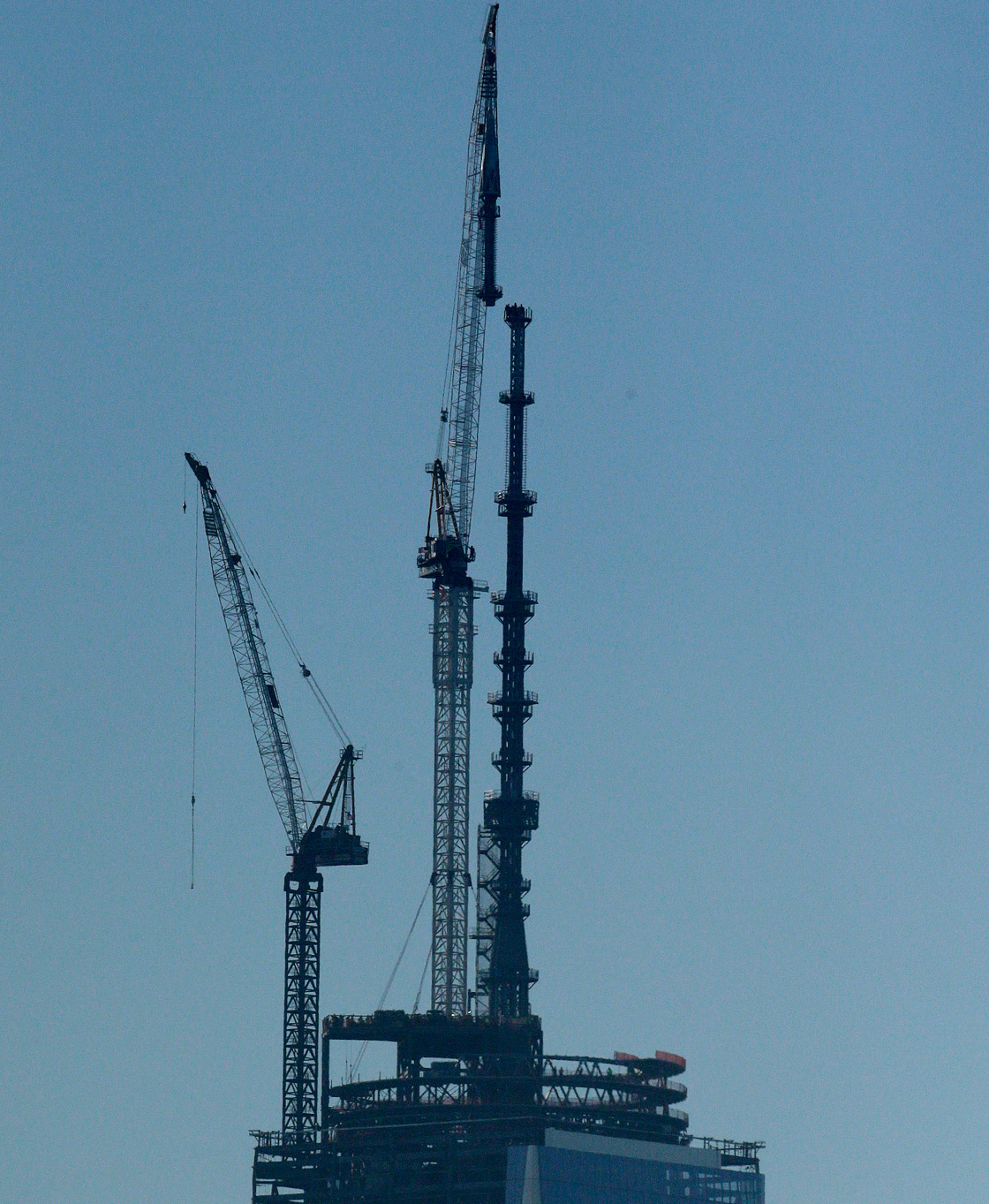 A crane lifts into place a 408-foot spire at the top of One World Trade Center seen from the Heights neighborhood of Jersey City, N.J., Friday, May 10, 2013.