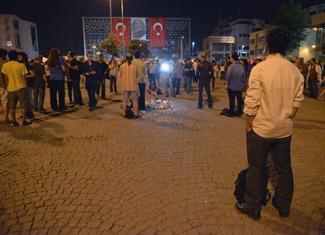 Erdem Gunduz, right, stands silently on Taksim Square in Istanbul, Turkey, early Tuesday, June 18, 2013. 