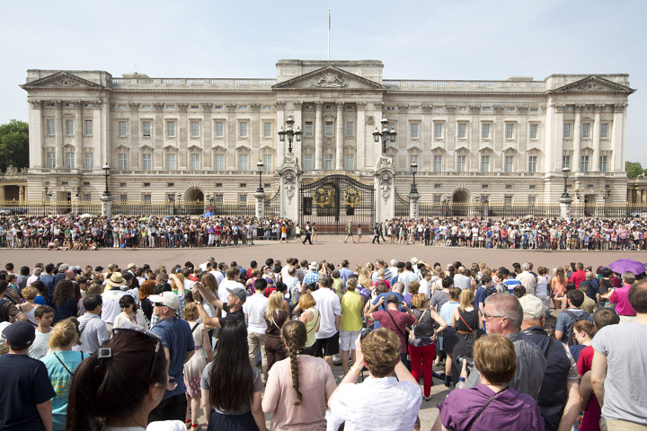 Crowds of tourists gather on the steps of the Queen Victoria Memorial Statue outside Buckingham Palace in central London on July 22, 2013. Prince William's wife Kate, (Catherine, Duchess of Cambridge) was admitted to hospital today in the early stages of labour as the world awaited the birth of a baby directly in line to inherit the British throne. It will then be made public in the traditional way, with a proclamation signed by royal doctors displayed on an easel in the Buckingham Palace forecourt -- the same easel used to announce William's birth in 1982. 