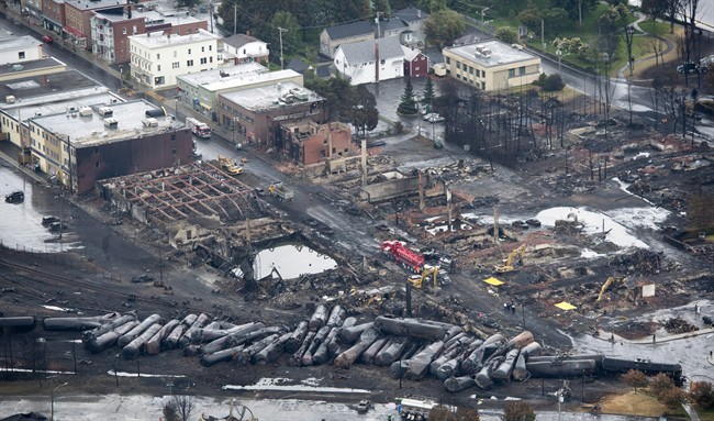 Workers comb through the debris after a train derailed causing explosions of railway cars carrying crude oil Tuesday, July 9, 2013 in Lac-Megantic, Quebec. THE CANADIAN PRESS/Paul Chiasson.
