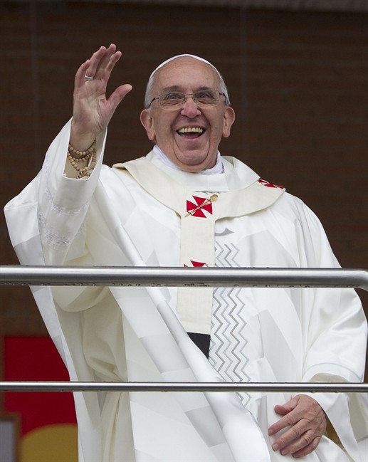 Pope Francis waves to pilgrims as he stands on a balcony at the Aparecida Basilica after celebrating Mass in Aparecida, Brazil, Wednesday, July 24, 2013.