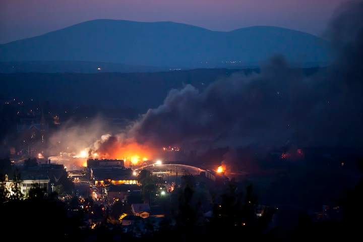 Firefighters douse blazes after a freight train loaded with oil derailed in Lac-Megantic, Que. on July 6, 2013, sparking explosions that engulfed the town.