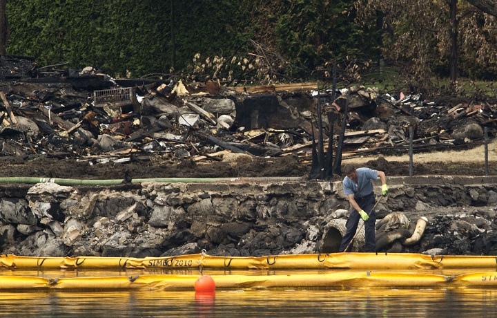 LAC-MEGANTIC QC - JULY 9: A worker directs crude oil into a pump on the edge of Lac-MÈgantic Tuesday afternoon in front of the explosion zone. Saturday's derailment sent thousands of liters of crude into Lac-MÈgantic and down the ChaudiËre River threatening towns and ecosystems downstream.