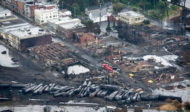 Workers comb through the debris after a train derailed causing explosions of railway cars carrying crude oil Tuesday, July 9, 2013 in Lac-Megantic, Que. 