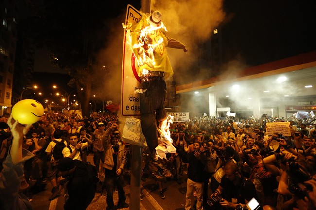 Protesters burn a puppet that symbolizes Rio de Janeiro State Governor Sergio Cabral during a demonstration near Guanabara Palace in Rio de Janeiro, Brazil, Monday, July 22, 2013. Police and anti-government protesters clashed outside the palace hosting Pope Francis welcoming ceremony. About an hour after the pope concluded his short speech, police began cracking down on the protests, firing rubber bullets in an effort to disperse the crowd. (AP Photo/Victor R. Caivano)