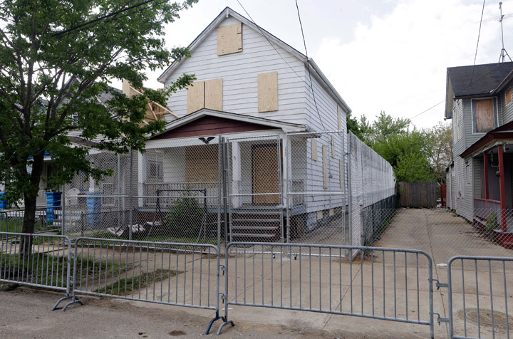 In this file photo, a 10-foot chain link fence surrounds the home of Ariel Castro in Cleveland on May 14, 2013. (Photo credit: AP Photo/File)