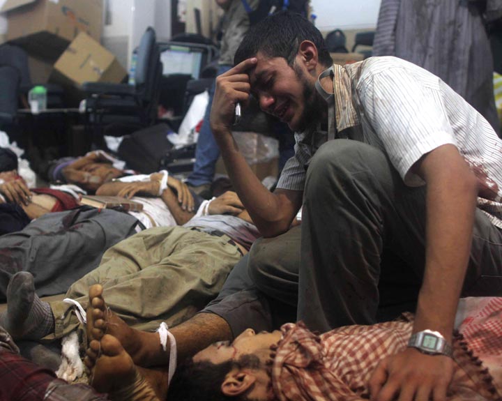 A man grieves as he looks at one of many bodies laid out in a makeshift morgue after Egyptian security forces stormed two huge protest camps at the Rabaa al-Adawiya and Al-Nahda squares where supporters of ousted president Mohamed Morsi were camped,  in Cairo, on August 14, 2013. Mosaab El-Shamy/AFP/Getty Images.