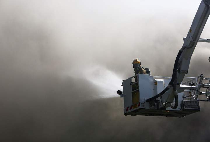 A fireman battles a house fire in Newtown on September 13, 2013 in Wellington, New Zealand. According to reports, people are believed to be trapped in the house fire on Millward Street in Newtown and fire services are on the scene. (Photo credit: Getty Images)