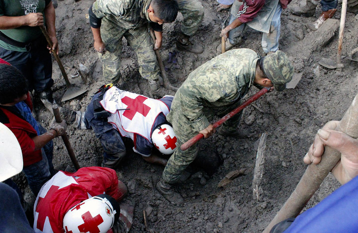 Mexican soldiers and Red Cross members look for victims of a landslide caused by heavy rains in Coscomatepec, Veracruz State, on September 10, 2013. (Photo credit: Getty Images)