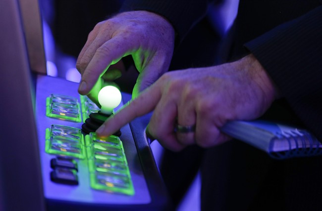 IGT account manager, George Kerrigan, demonstrates the use of a joystick and various buttons to play the Centipede video game slot machine at the Global Gaming Expo, Wednesday, Sept. 25, 2013, in Las Vegas. As the slot machine undergoes a generational shift, manufacturers are rolling out the first generation of joystick-controlled, penny arcade-themed gambling machines.