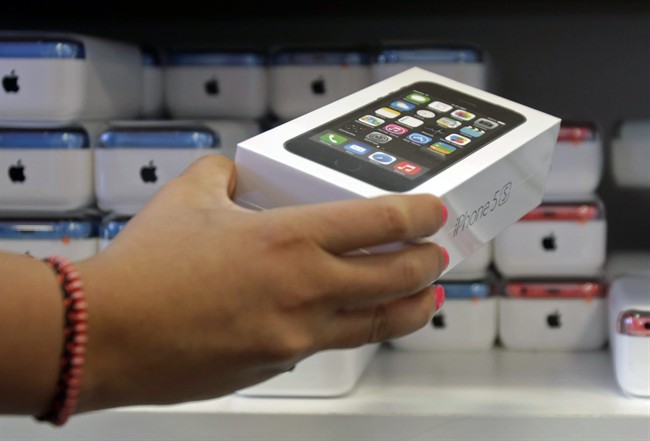 A sales person pulls out an iPhone 5s for a customer during the opening day of sales of the iPhone 5s and iPhone 5C.