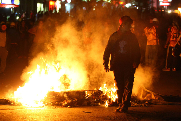 Demonstrators light fires during a protest against a government project, the first ever cultural center containing an Alevi cemevi and a Sunni mosque side by side, in the Tuzlucayir neighborhood of Ankara, on September 12, 2013