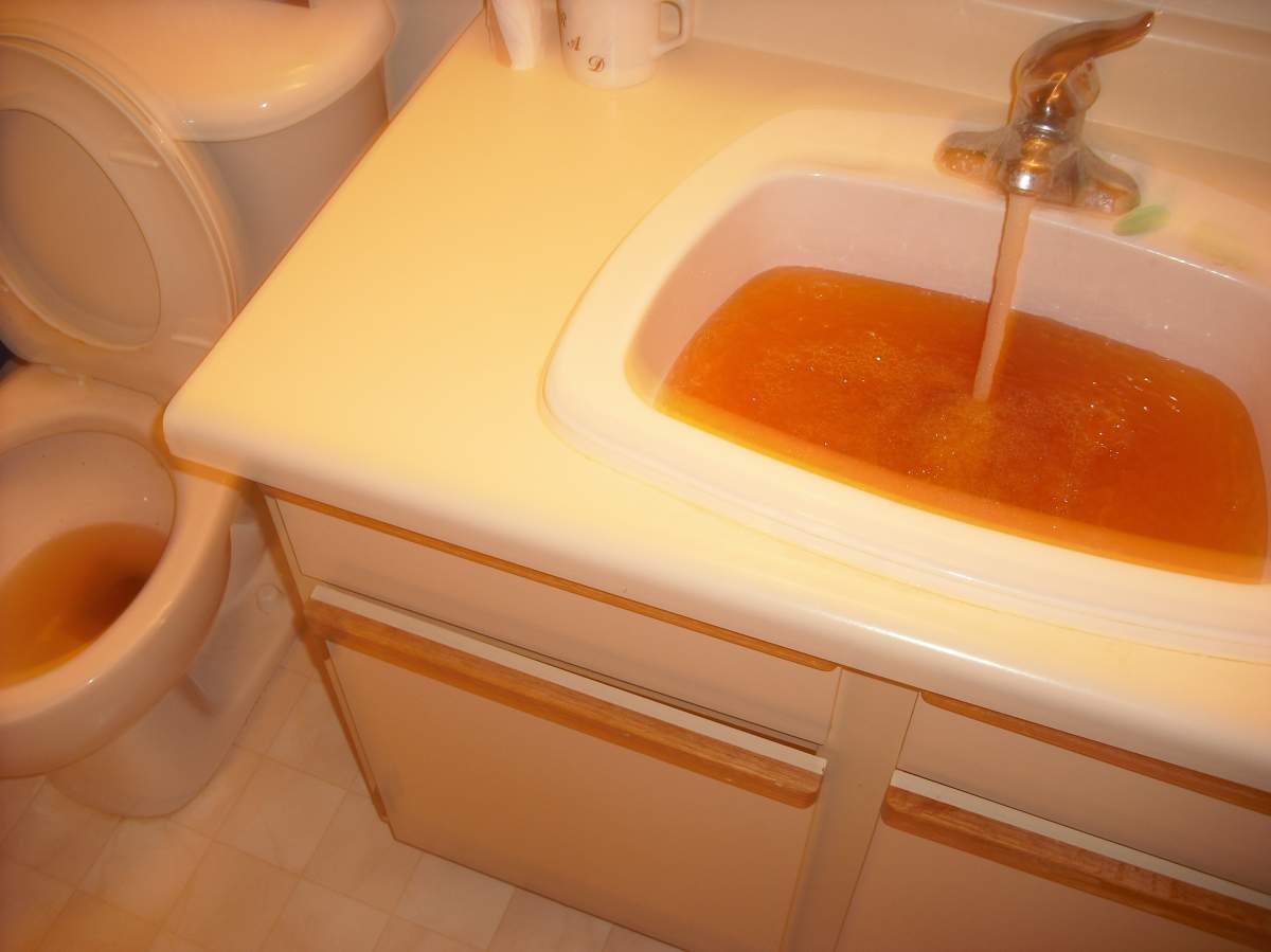 Brown water pours from a tap in Winnipeg in fall.