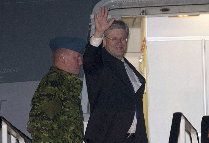 Prime Minister Stephen Harper waves as he arrives in Brussels, Belgium Friday October 18, 2013.