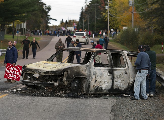 A burned police vehicle is seen in Rexton, N.B. as police began enforcing an injunction to end an ongoing demonstration against shale gas exploration on Oct.17, 2013.
