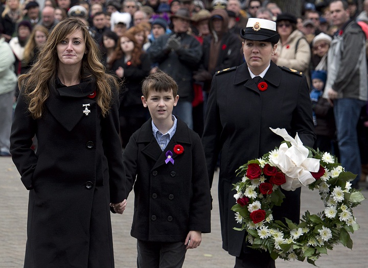 Memorial Cross recipient Priscilla Blake, and her son Tie head to lay a wreath at Remembrance Day cermonies at the Grand Parade in Halifax on Monday, Nov. 11, 2013. Her husband, Petty Officer (second class) Craig Blake, a navy clearance diver was killed by by an explosive device in Afghanistan in 2010. (The Canadian Press/Andrew Vaughan)