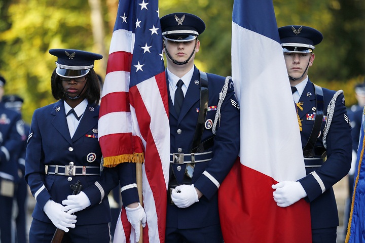 US Air Force soldiers hold French and US flags as they attend the Remembrance Day ceremony at The Lafayette Escadrille Memorial of Marnes-la-Coquette, east of Paris, on November 11, 2013. (Thomas Samson/Getty Images)