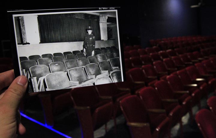 This Sept. 9, 2013 photo shows an image provided by the City of Dallas Archive taken Nov. 22, 1963, of a Dallas police officer pointing to the seat at the Texas Theatre where Lee Harvey Oswald was sitting when police entered to arrest him, juxtaposed against the current scene in Dallas. (AP Photo/Houston Chronicle, Cody Duty)
