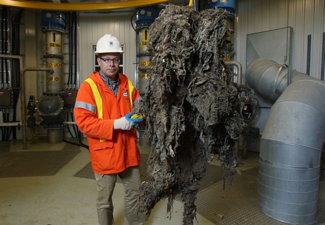 Barry Orr of the City of London Environmental and Engineering Services lifts a giant mass of material, primarily wipes that are supposed to be flushable, that had been clogging the sewage system pumps in London, ON, Friday, Nov. 15, 2013.
