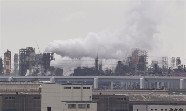 In this Monday, Oct. 21, 2013 photo, smoke billows from an oil refinery in Kawasaki, southwest of Tokyo. 