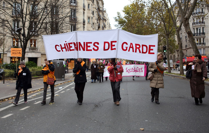 Activists from French feminist ‘Chiennes de garde’ association (Guard dogs) hold a banner during a demonstration for the abolition of prostitution and the elimination of violence against women called by the Women rights national collective, on November 23, 2013 in Paris. (Photo credit: Getty Images)
