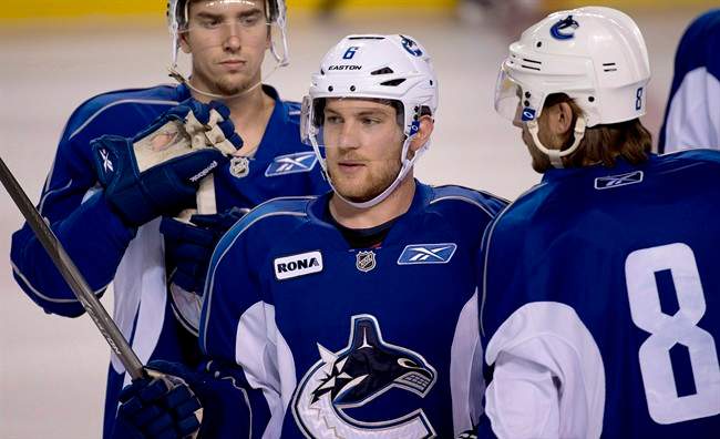 FILE PHOTO: Vancouver Canuck Yannick Weber of Switzerland, centre, speaks with Chris Tanev, right during the teams training camp at the UBC arena in Vancouver, B.C. 