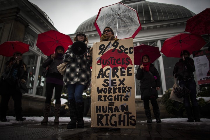 Nina Choi holds speaks during rally at Allan Gardens park to support Toronto sex workers and their rights in Toronto, Friday December 20, 2013.
