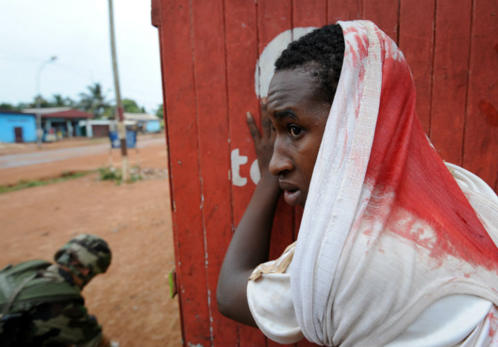 A wounded man waits for assistance during a disarmament operation by French soldiers in Bangui, on December 9, 2013. French troops on Monday began disarming fighters in the Central African Republic after a swell in sectarian violence that has claimed hundreds of lives and terrified inhabitants. (Photo by: Sia Kambou/AFP/Getty Images)