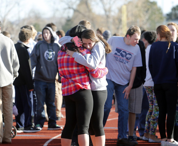 Students comfort each other at Arapahoe High School in Centennial, Colo., on Friday, Dec. 13, 2013, where a student shot at least one other student at a Colorado high school Friday before he apparently killed himself, authorities said. AP Photo/Ed Andrieski)