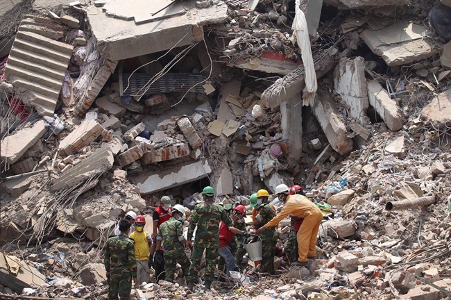 Workers try to release two bodies trapped in the rubble of collapsed Rana Plaza garment factory building in Savar, near Dhaka, Bangladesh, April 30, 2013. More than 1,100 garment workers were killed in the Bangladesh factory collapse in April.