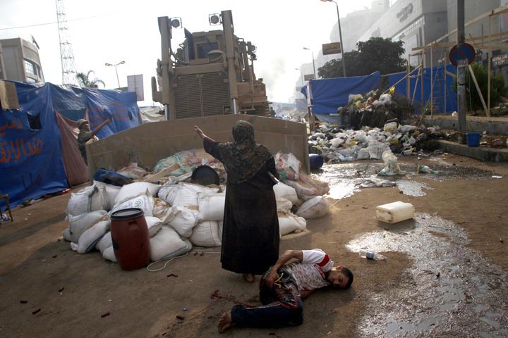 An Egyptian woman tries to stop a military bulldozer from hurting a wounded youth during clashes in Cairo, Egypt. (Mohammed Abdel Moneim/AFP/Getty Images)
