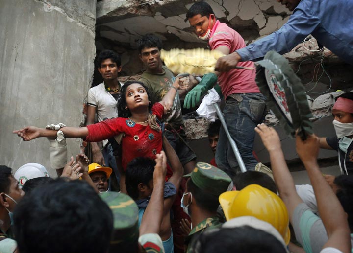 A survivor is lifted out of the rubble by rescuers at the site of a building that collapsed in Savar, near Dhaka, Bangladesh. (AP Photo/Kevin Frayer)