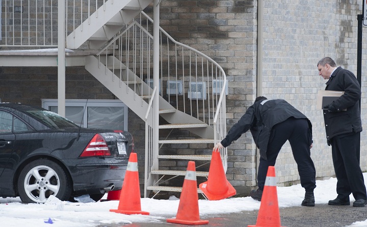 Montreal police officers survey the scene in Montreal, Monday, Dec., 28, 2009 where a man was shot, believed to be alleged mobster Nic Rizzuto Jr.