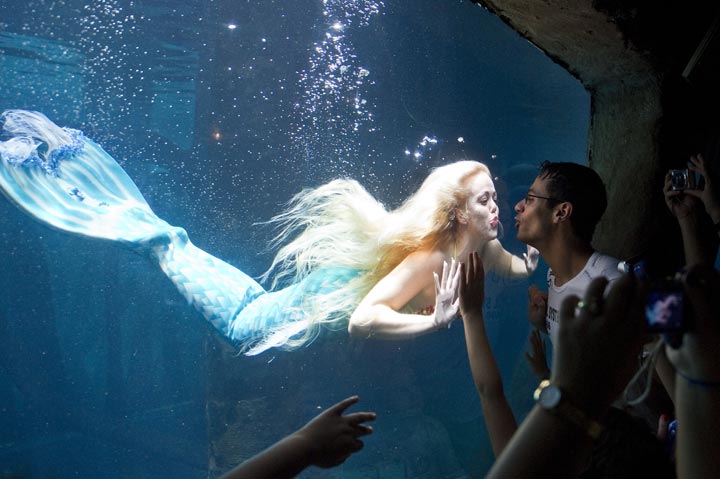 Visitors watch a mermaid as she swims in a giant tank at an aquarium in Sao Paulo, Brazil. (Nelson Almeida/AFP/Getty Images)
