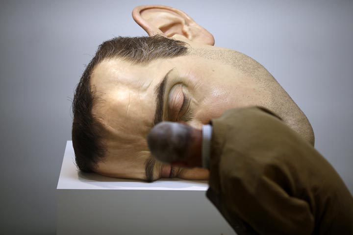 A man looks at a sculpture by Australian artist Ron Mueck  at an exhibit in Paris. (Thomas Coex/AFP/Getty Images)
.