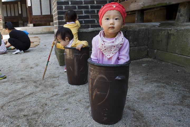 A child appears to be stuck inside a ceramic container while playing with other children at food festival in Seoul, South Korea. (Jacquelyn Martin/AFP/Getty Images)