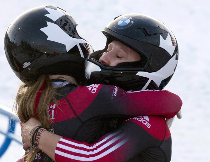 Kaillie Humphries, right, and Heather Moyes hug after winning the women’s World Cup bobsled race in Calgary, Alta., Saturday, November 30, 2013. (Larry MacDougal / The Canadian Press)
