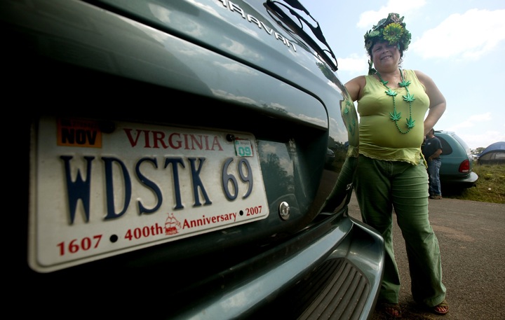 Skyfeather stands next to her custom licence plate near where the concert marking the 40th anniversary of the Woodstock music festival will be held.