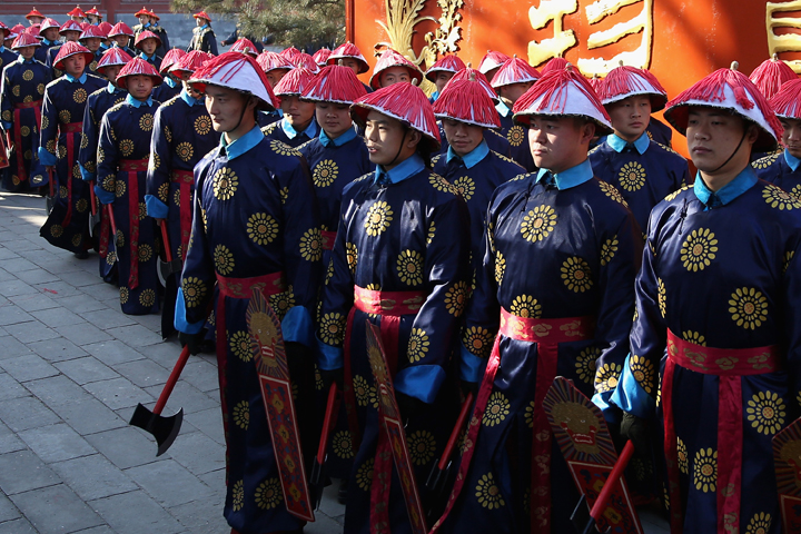 Chinese paramilitary police officers dressed as Qing Dynasty servants before a re-enactment of an ancient ceremony of Qing Dynasty emperors praying for good harvest and fortune during the opening ceremony of the Spring Festival Temple Fair at the Temple of Earth park on Jan. 30, 2014 in Beijing, China. (Photo credit: Feng Li/Getty Images)
