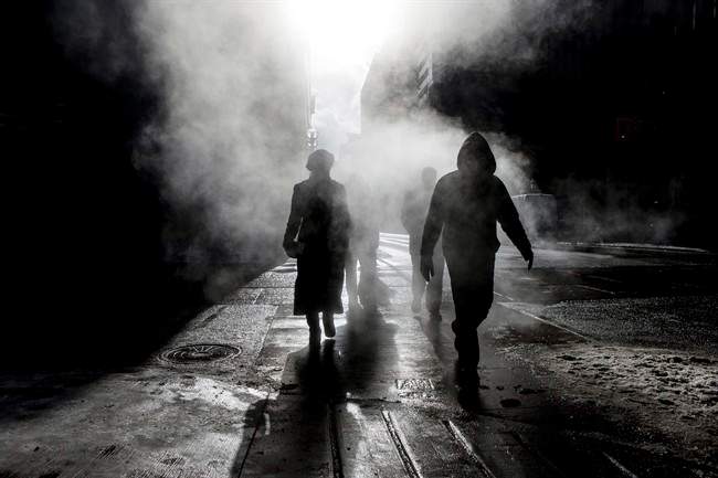 Pedestrians cross an intersection near a subway steam vent in downtown Toronto in Jan. 2014. Environment Canada has issued an extreme cold alert for the city, with wind chills expected to make it feel as cold as -40 C in Toronto.